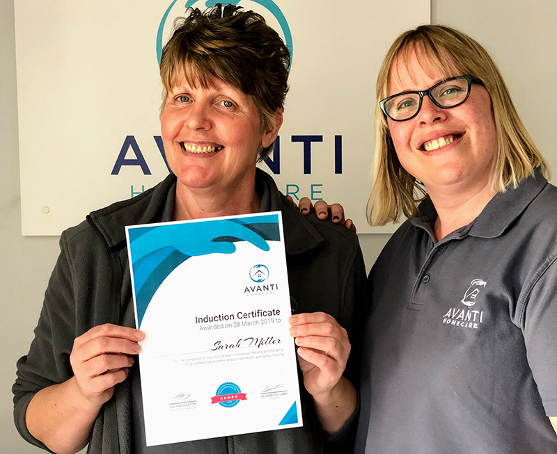 Lucy gives Sarah here induction certificate at Avanti Homecare office.